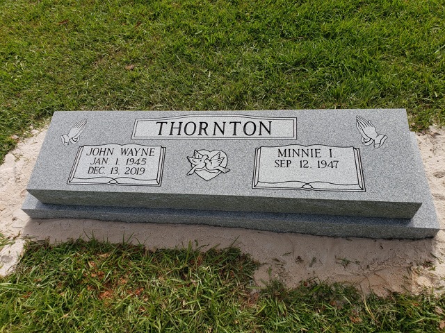 Standing companion headstone with a carving of praying hands and doves